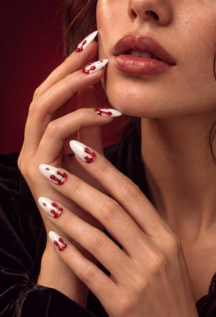 Long ivory almond nails with glossy cat-eye red blood-drip nail art for a bold vampire-inspired Halloween manicure
