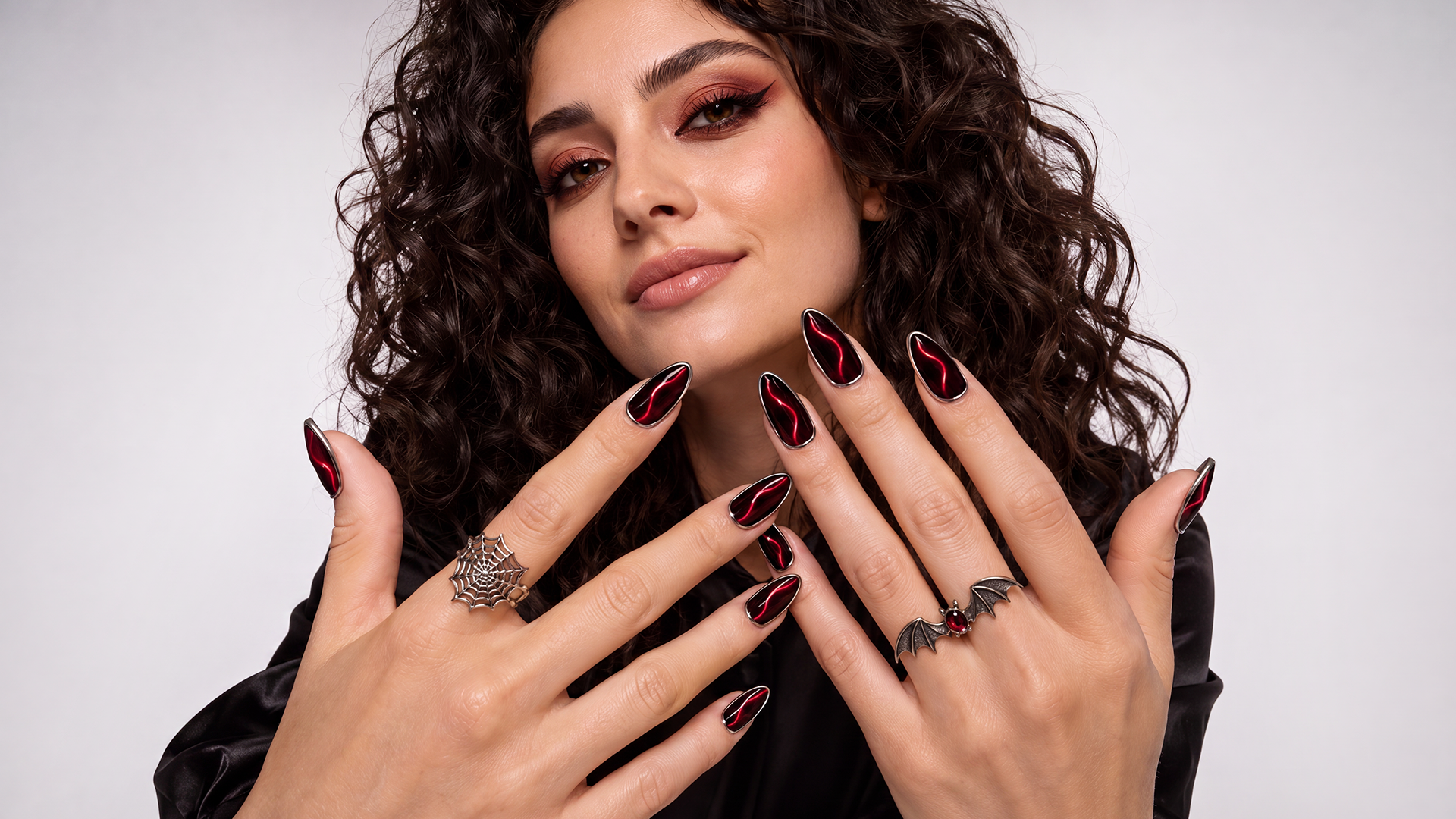 Almond nails featuring a mysterious red-and-black cat-eye effect and metallic silver edges create a stylish "Blood Moon" look, perfectly embodying a bold and mysterious Gothic aesthetic.