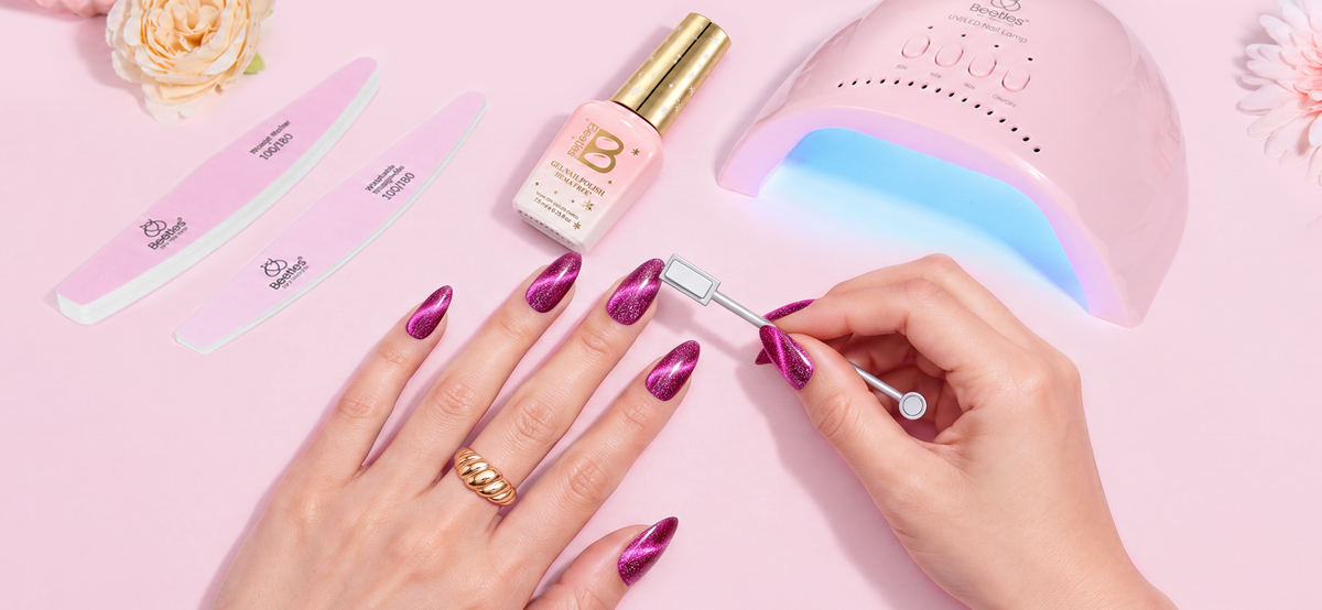 Beginner creating cat eye nails at home with magnetic gel polish and a nail magnet