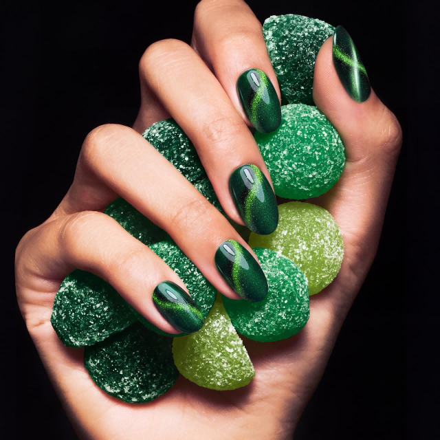 Green cat-eye nails with sharp magnetic line and iridescent shimmer.